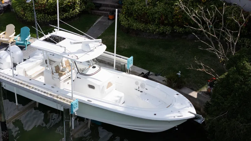 Dan's Seachelle Yacht Photos Pics 2019 Edgewater 320CC boat docked in a lush, green marina setting.