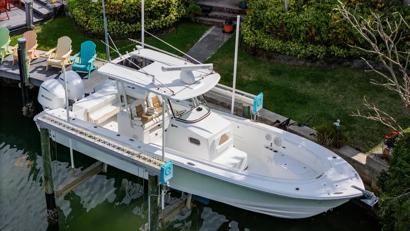 Dan's Seachelle Yacht Photos Pics 2019 Edgewater 320CC boat docked by lush greenery.