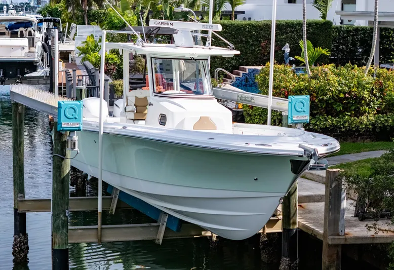 Dan's Seachelle Yacht Photos Pics 2019 Edgewater 320CC boat docked on a lift in a marina setting.
