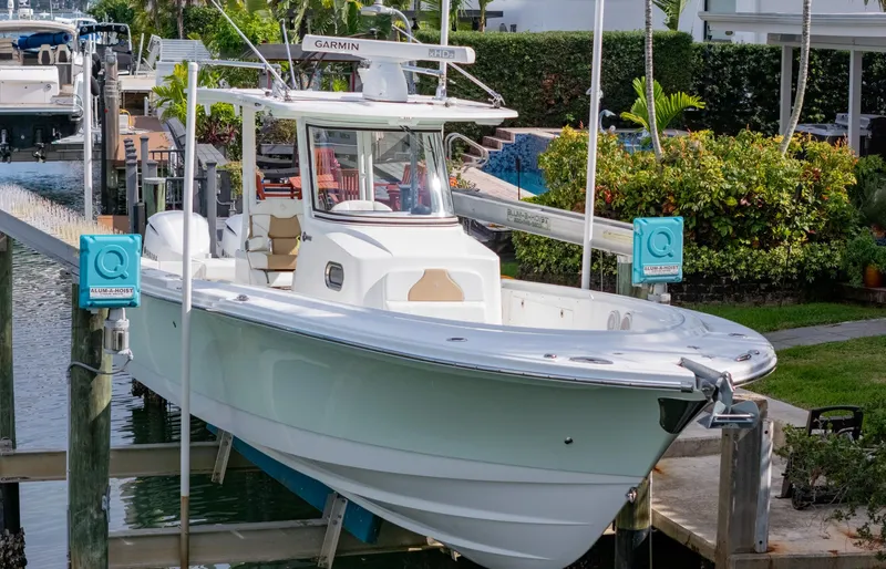 Dan's Seachelle Yacht Photos Pics 2019 Edgewater 320CC boat docked at marina, surrounded by lush greenery.