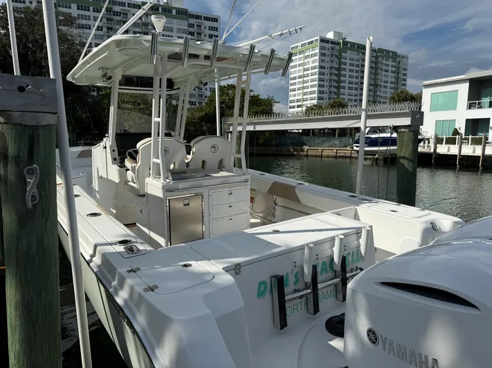 Dan's Seachelle Yacht Photos Pics 2019 Edgewater 320CC boat docked near waterfront buildings.