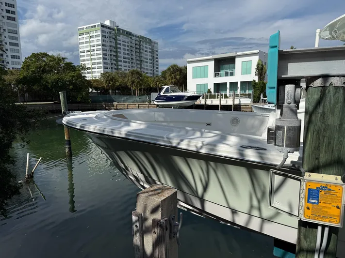 Dan's Seachelle Yacht Photos Pics Edgewater 320CC 2019 boat docked near modern waterfront buildings.