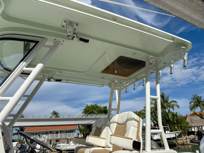 Dan's Seachelle Yacht Photos Pics 2019 Edgewater 320CC boat with seating and canopy, docked under a clear blue sky.