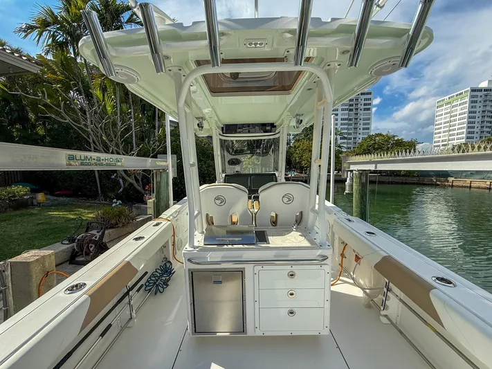 Dan's Seachelle Yacht Photos Pics 2019 Edgewater 320CC boat interior with seating and storage, docked near waterfront buildings.