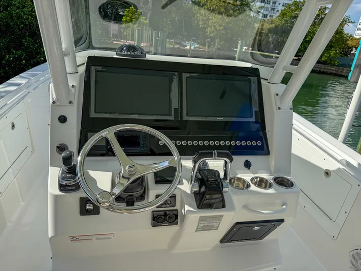 Dan's Seachelle Yacht Photos Pics Edgewater 320CC 2019 boat dashboard with dual screens and steering wheel.