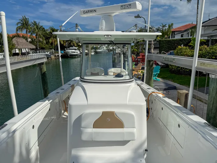 Dan's Seachelle Yacht Photos Pics 2019 Edgewater 320CC boat docked in a scenic canal with palm trees.