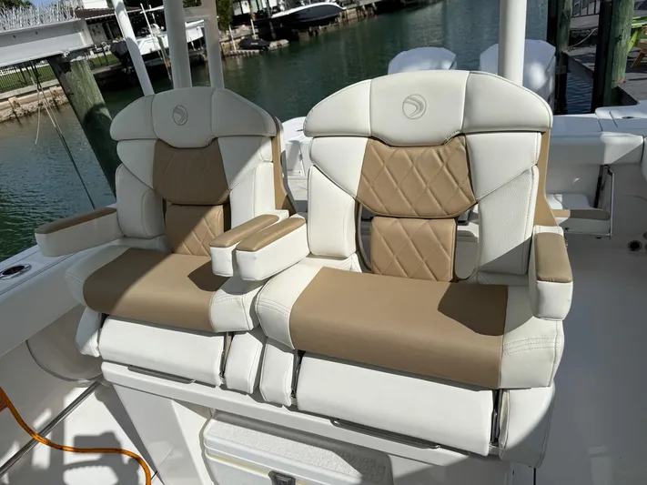 Dan's Seachelle Yacht Photos Pics Luxurious seating on 2019 Edgewater 320CC boat, featuring tan and white upholstery.