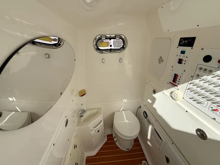 Dan's Seachelle Yacht Photos Pics Interior of 2019 Edgewater 320CC boat bathroom with toilet, sink, and control panel.
