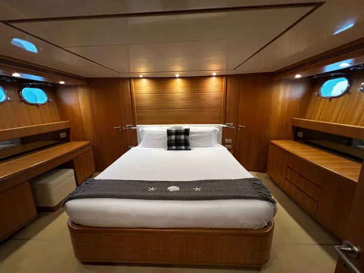 Koko Yacht Photos Pics Luxurious master bedroom on 2006 Sanlorenzo SL72 yacht with wood paneling and modern lighting.