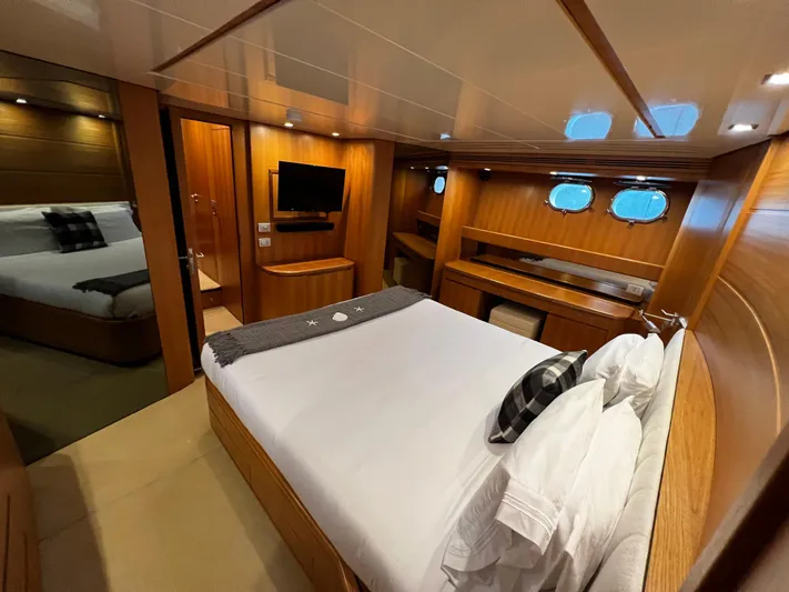 Koko Yacht Photos Pics Luxurious bedroom on a 2006 Sanlorenzo SL72 yacht with wood paneling and modern amenities.