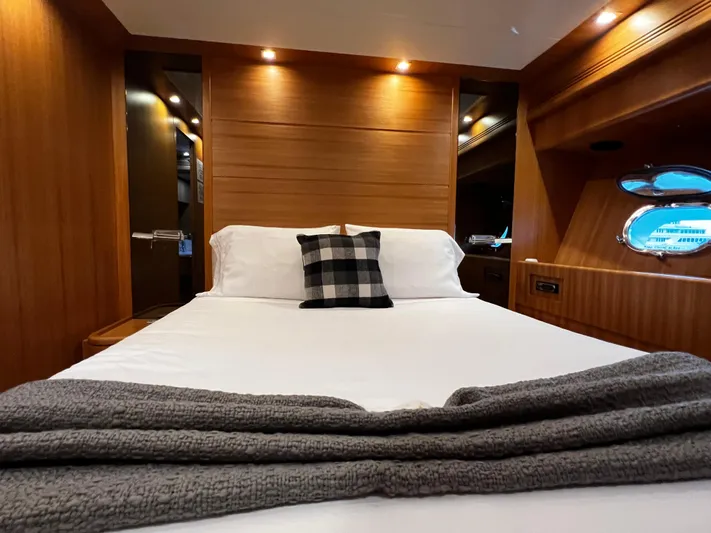 Koko Yacht Photos Pics Luxurious bedroom interior of 2006 Sanlorenzo SL72 yacht with cozy bed and wooden finish.