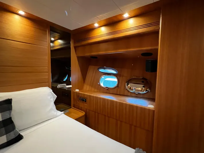 Koko Yacht Photos Pics Sanlorenzo SL72 2006 yacht cabin with wooden interior and porthole windows.