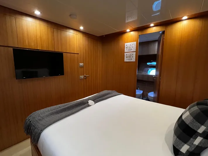 Koko Yacht Photos Pics Luxurious bedroom on 2006 Sanlorenzo SL72 yacht with wood paneling and ensuite bathroom.