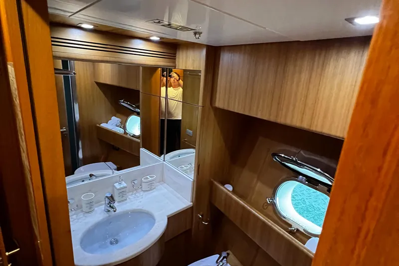 Koko Yacht Photos Pics Luxurious bathroom in a 2006 Sanlorenzo SL72 yacht with wood paneling and porthole window.