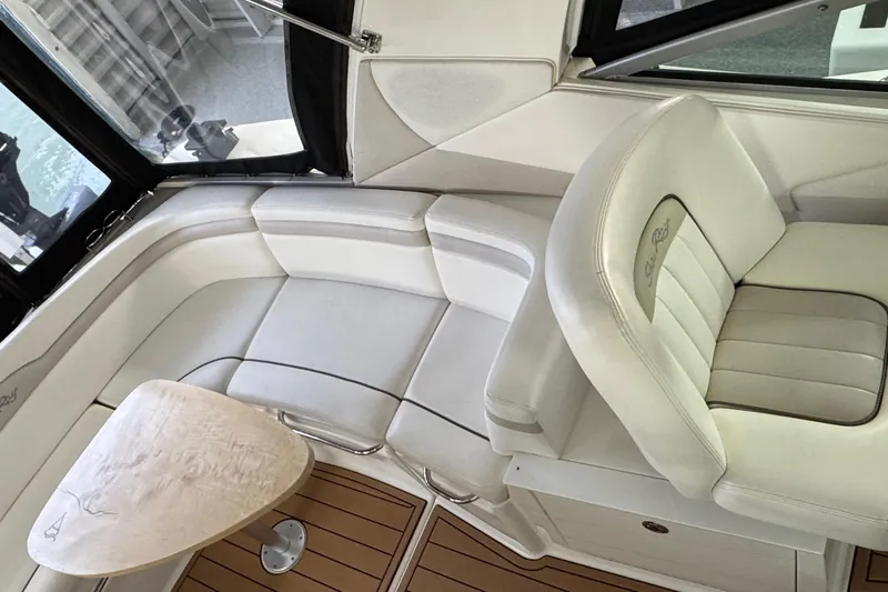  Yacht Photos Pics Interior of 2011 Sea Ray 370 Sundancer with white seating and wooden table.