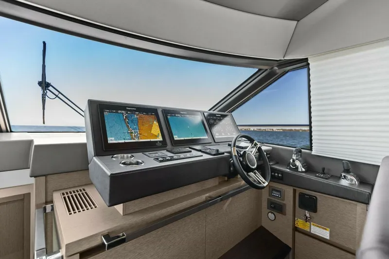 Radiant Yacht Photos Pics Prestige 630 Flybridge 2019 yacht helm with navigation screens and steering wheel.