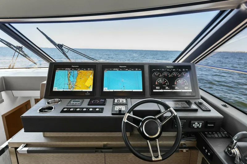 Radiant Yacht Photos Pics Prestige 630 Flybridge 2019 yacht helm with navigation screens and steering wheel.