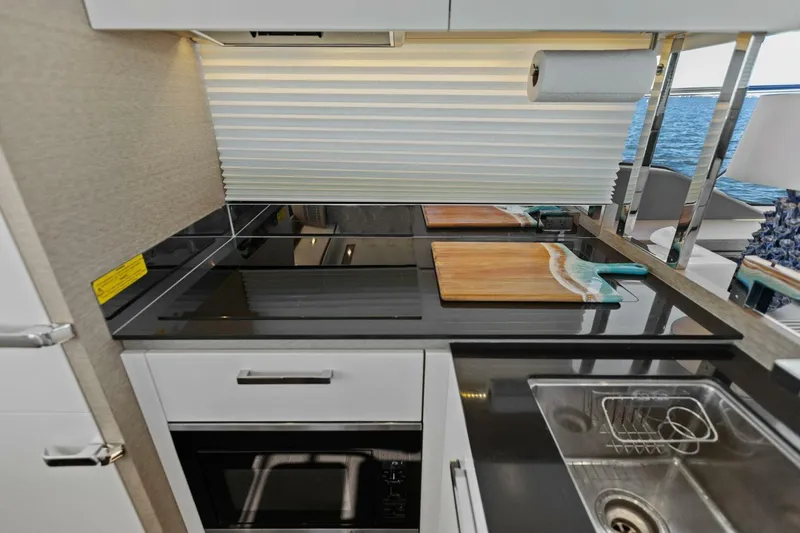 Radiant Yacht Photos Pics Modern kitchen on 2019 Prestige 630 Flybridge yacht with sleek countertops and appliances.