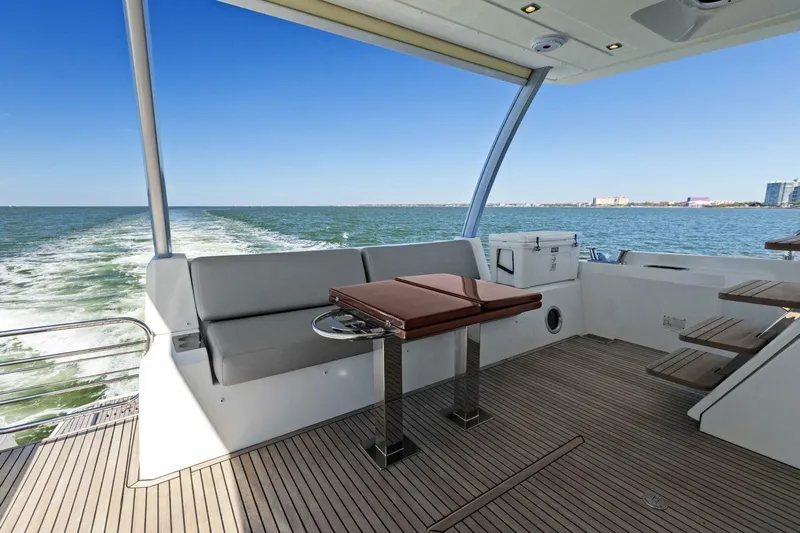 Radiant Yacht Photos Pics Prestige 630 Flybridge 2019 yacht deck with seating and table, cruising on open water.