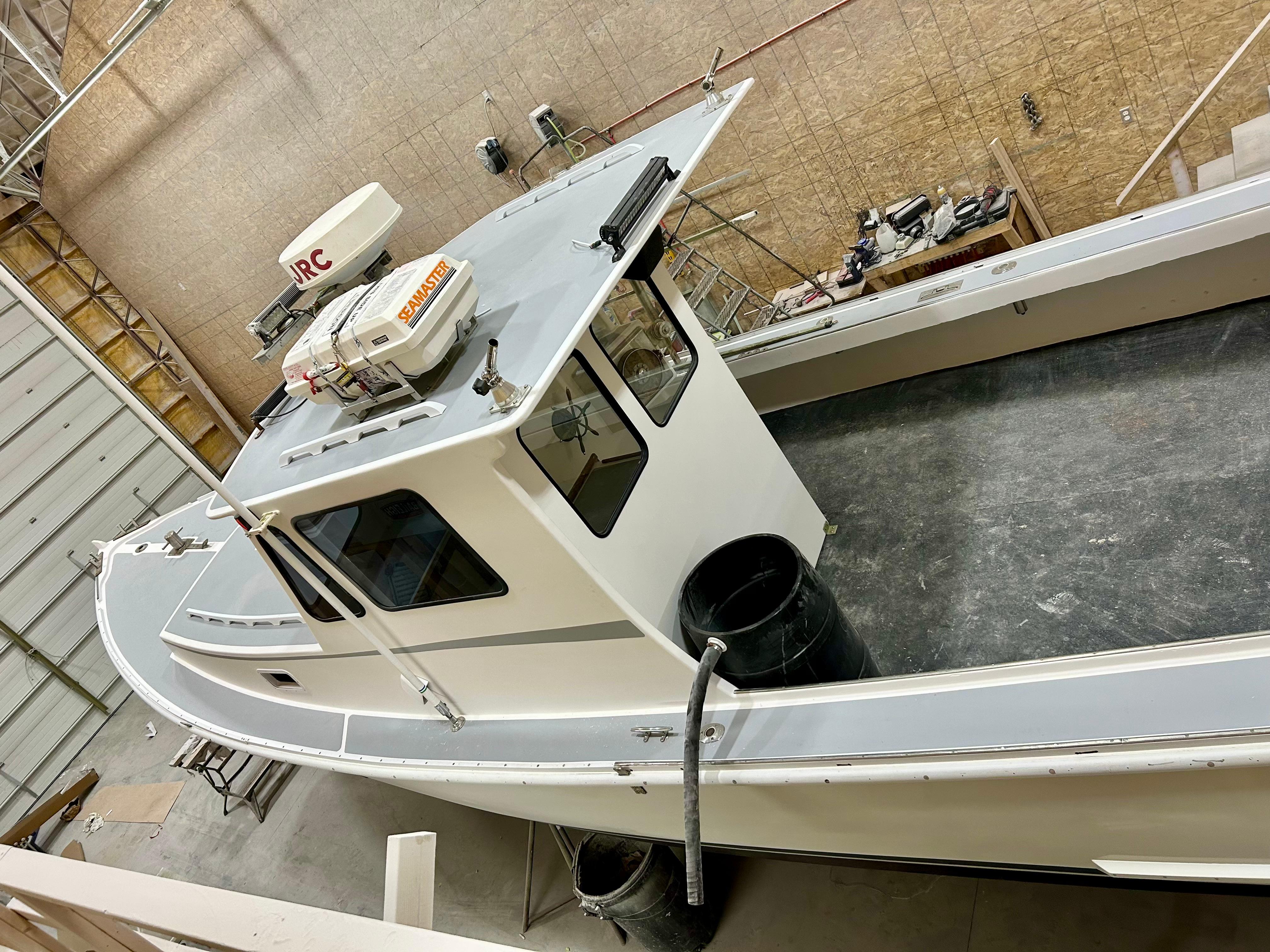 1980 Holland 32 boat in a workshop, featuring a clean deck and cabin.