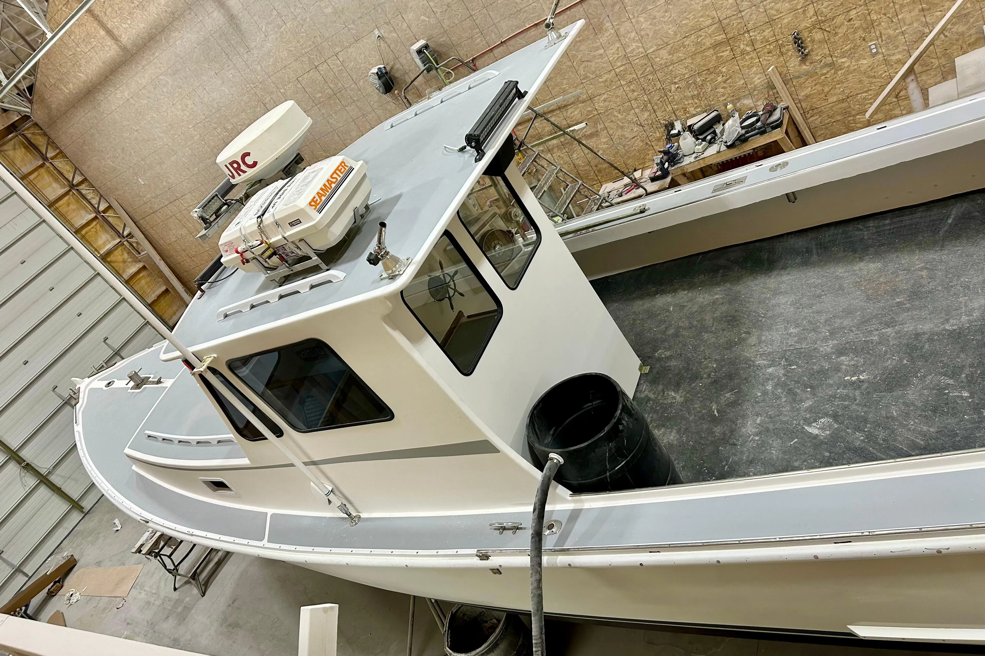 1980 Holland 32 boat in a workshop, featuring a clean deck and cabin.