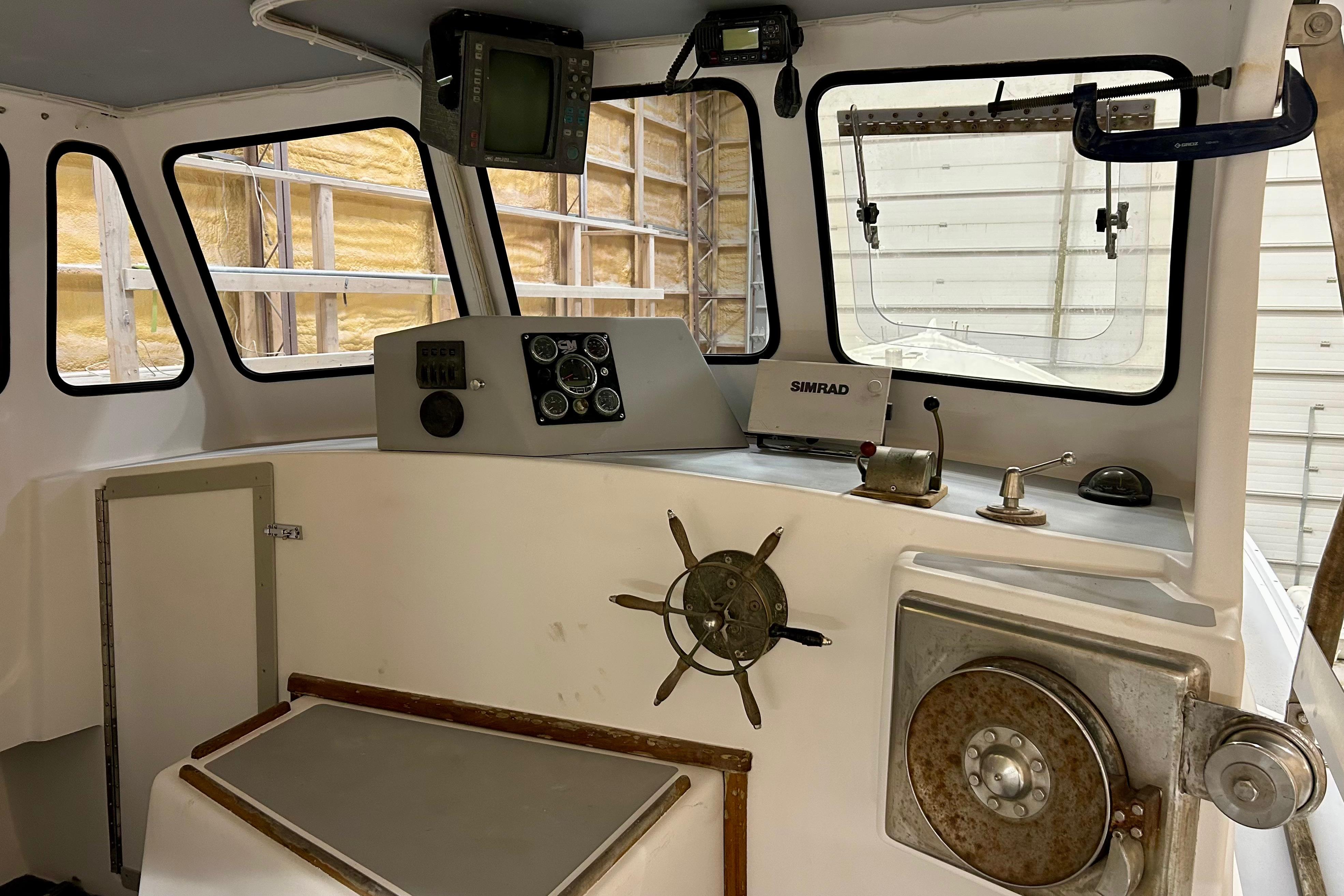 Interior of a 1980 Holland 32 boat, featuring navigation equipment and steering wheel.