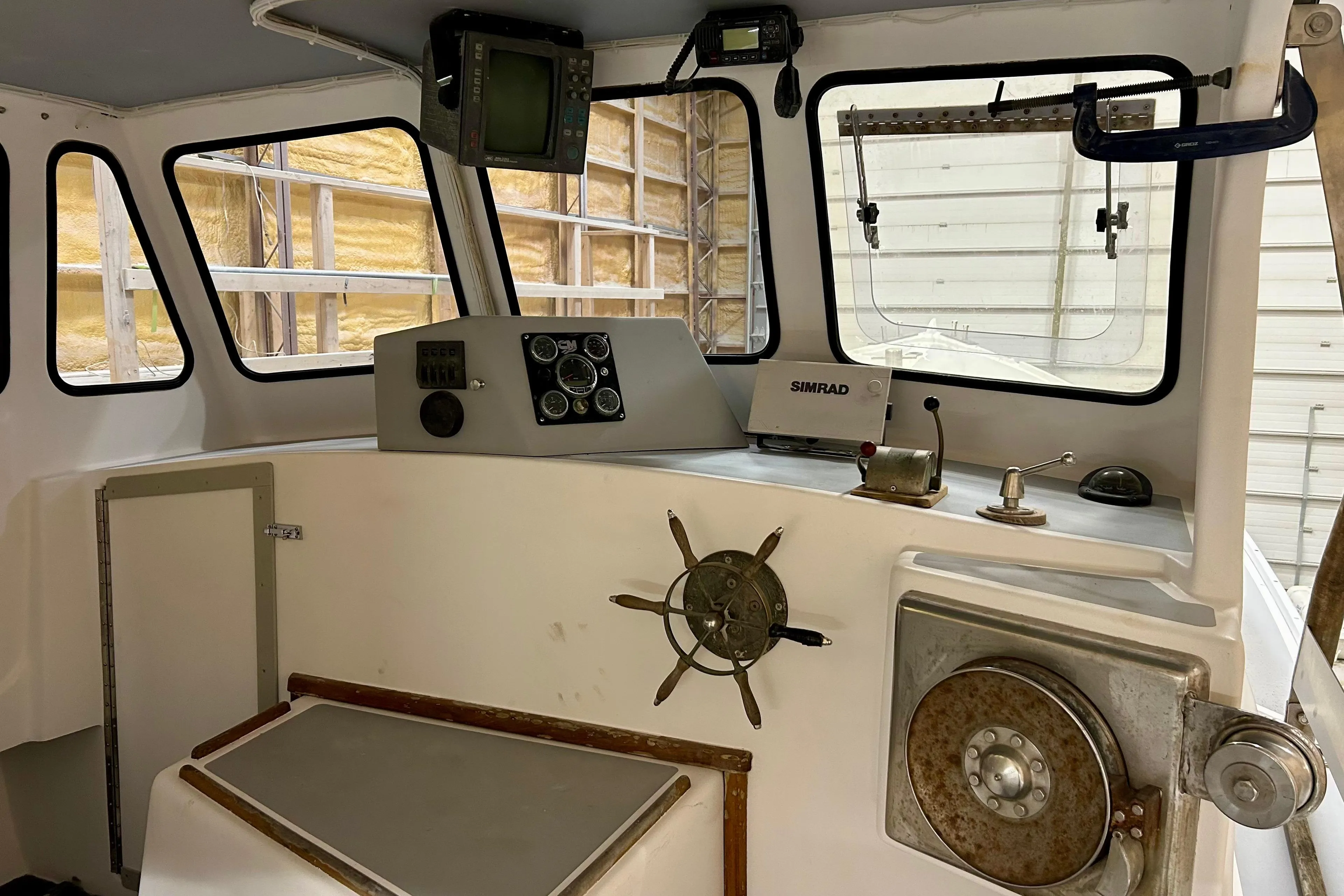 Interior of a 1980 Holland 32 boat, featuring navigation equipment and steering wheel.