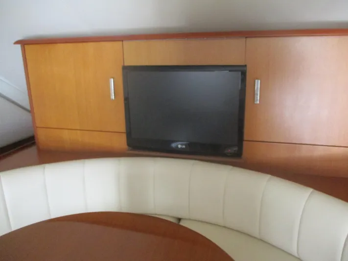 Persian Lady Yacht Photos Pics 1997 Ocean Yachts 40 Super Sport interior with TV and curved seating.