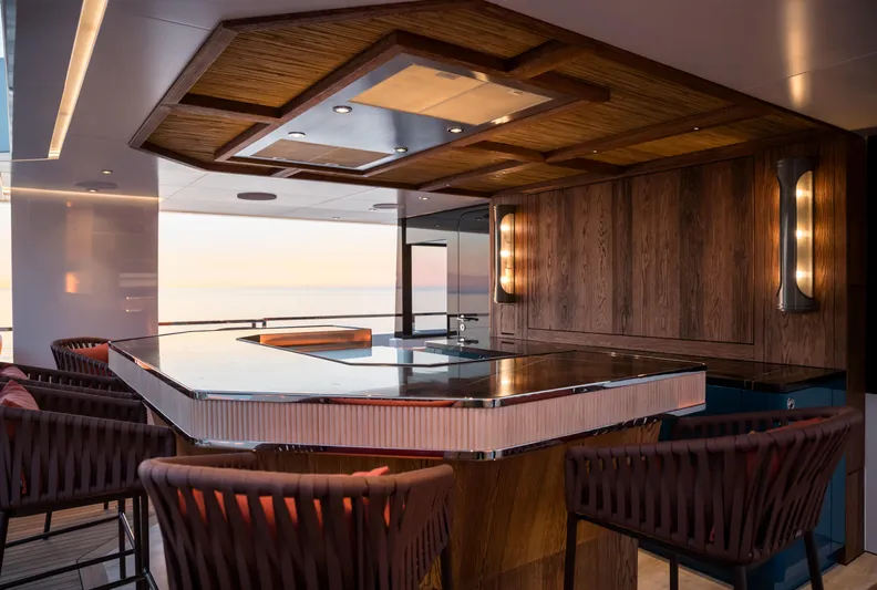 King Benji Yacht Photos Pics Luxurious bar area on 2024 Dunya Yacht, featuring elegant wood paneling and modern lighting.