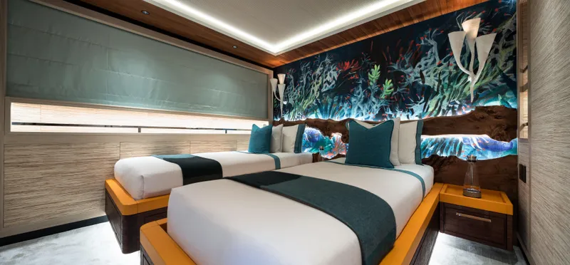 King Benji Yacht Photos Pics Luxurious 2024 Dunya Yachts bedroom with twin beds, ocean-themed decor, and ambient lighting.