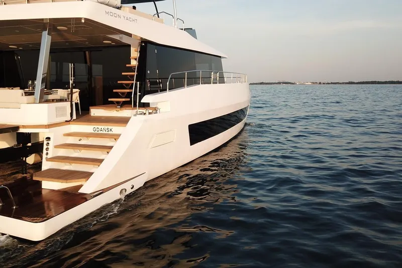 Moon 60 Power Arctic Moon Yacht Photos Pics Luxurious 2025 Moon 60 Power yacht cruising on serene waters at sunset.