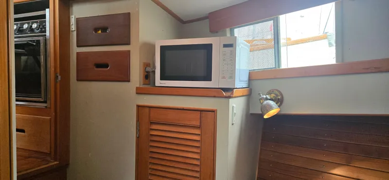 Interlude Yacht Photos Pics Interior of 1987 Grand Banks 36 Classic with microwave and wooden cabinetry.