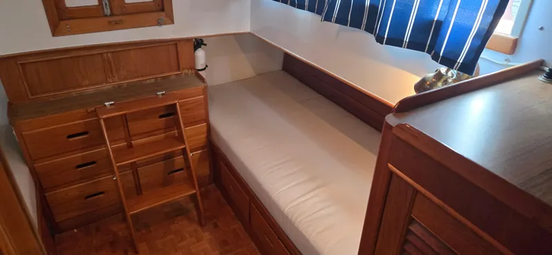Interlude Yacht Photos Pics 1987 Grand Banks 36 Classic cabin interior with wooden furniture and a single bed.