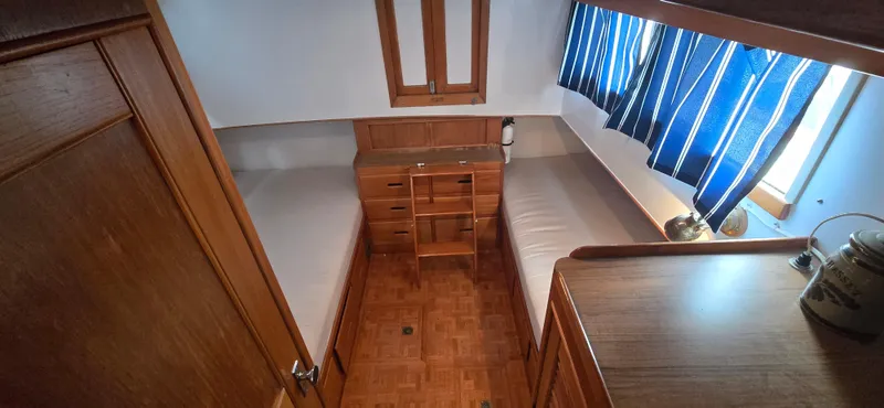 Interlude Yacht Photos Pics 1987 Grand Banks 36 Classic cabin with twin beds, wooden interior, and blue-striped curtains.