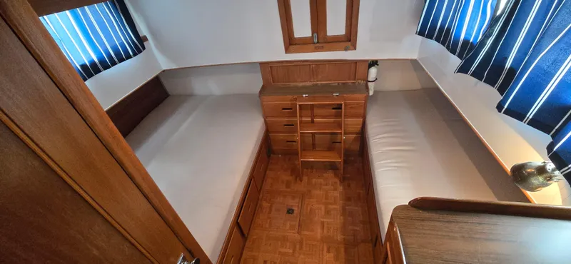 Interlude Yacht Photos Pics 1987 Grand Banks 36 Classic cabin with twin beds, wooden interior, and striped curtains.