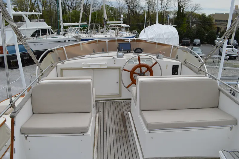 Interlude Yacht Photos Pics 1987 Grand Banks 36 Classic yacht cockpit with wooden wheel and cushioned seating.
