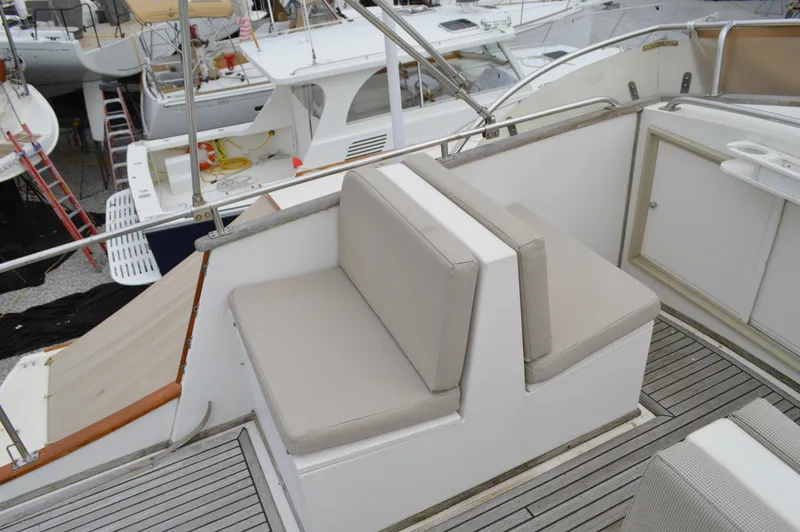 Interlude Yacht Photos Pics 1987 Grand Banks 36 Classic yacht with cushioned seating on deck, docked among other boats.