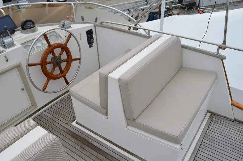 Interlude Yacht Photos Pics 1987 Grand Banks 36 Classic yacht helm with wooden wheel and cushioned seating.
