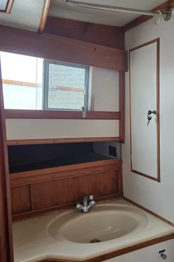 Interlude Yacht Photos Pics 1987 Grand Banks 36 Classic yacht bathroom with sink and wooden cabinetry.