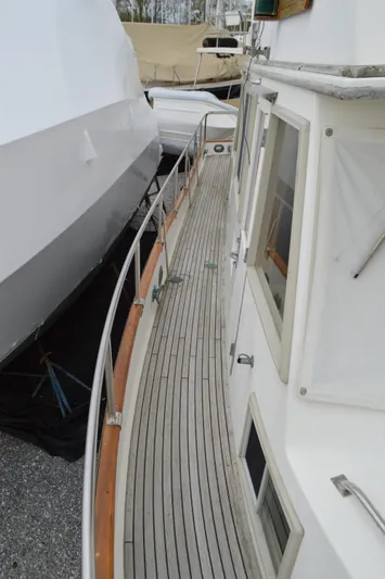 Interlude Yacht Photos Pics 1987 Grand Banks 36 Classic yacht with wooden deck and white exterior, docked beside another boat.