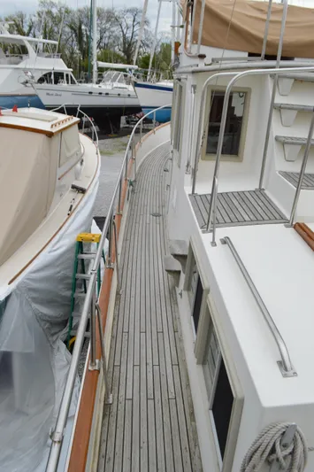 Interlude Yacht Photos Pics 1987 Grand Banks 36 Classic yacht with wooden deck, docked alongside another boat.