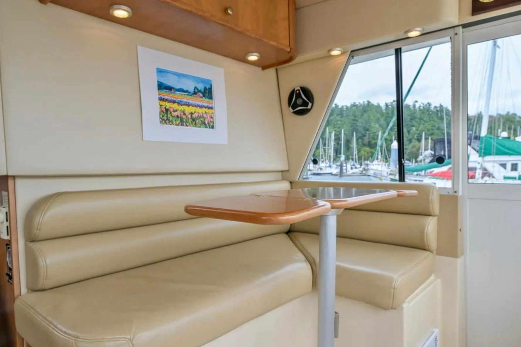 Interior of 2004 Meridian 490 Pilothouse with beige seating and marina view.