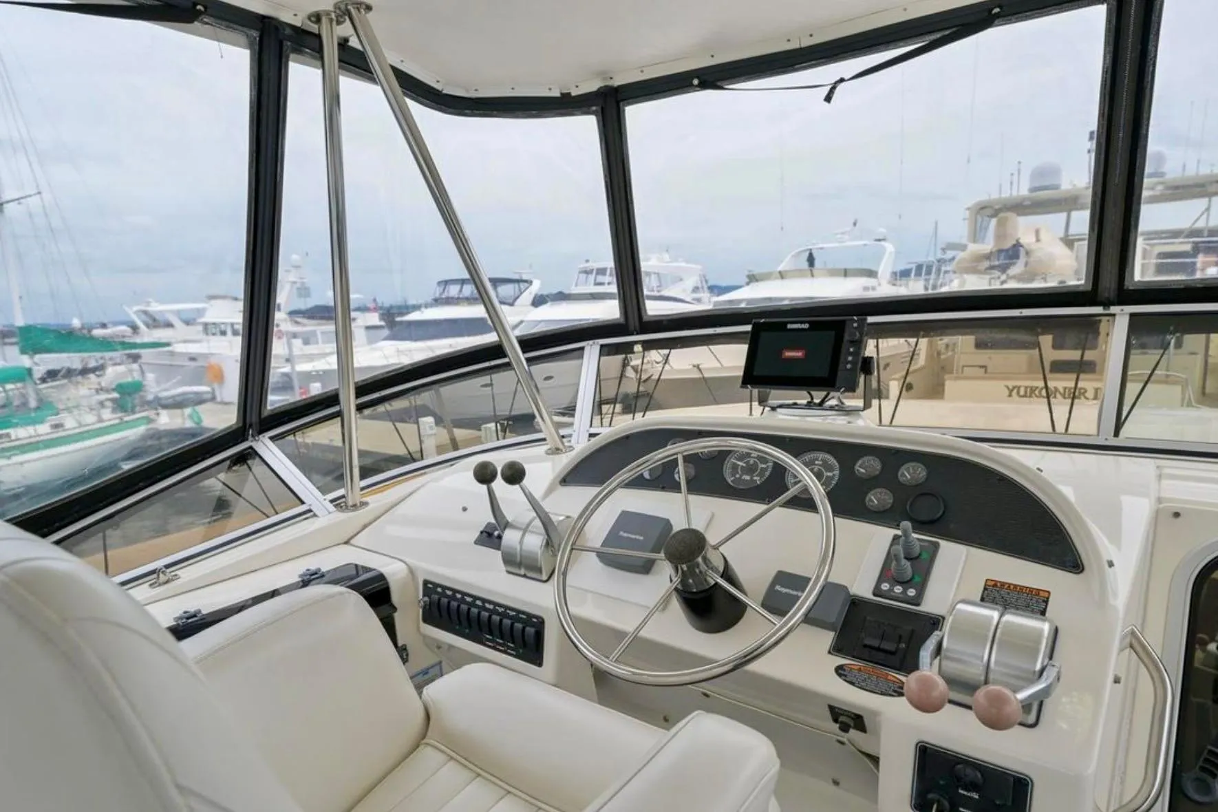 2004 Meridian 490 Pilothouse interior with steering wheel and navigation equipment.