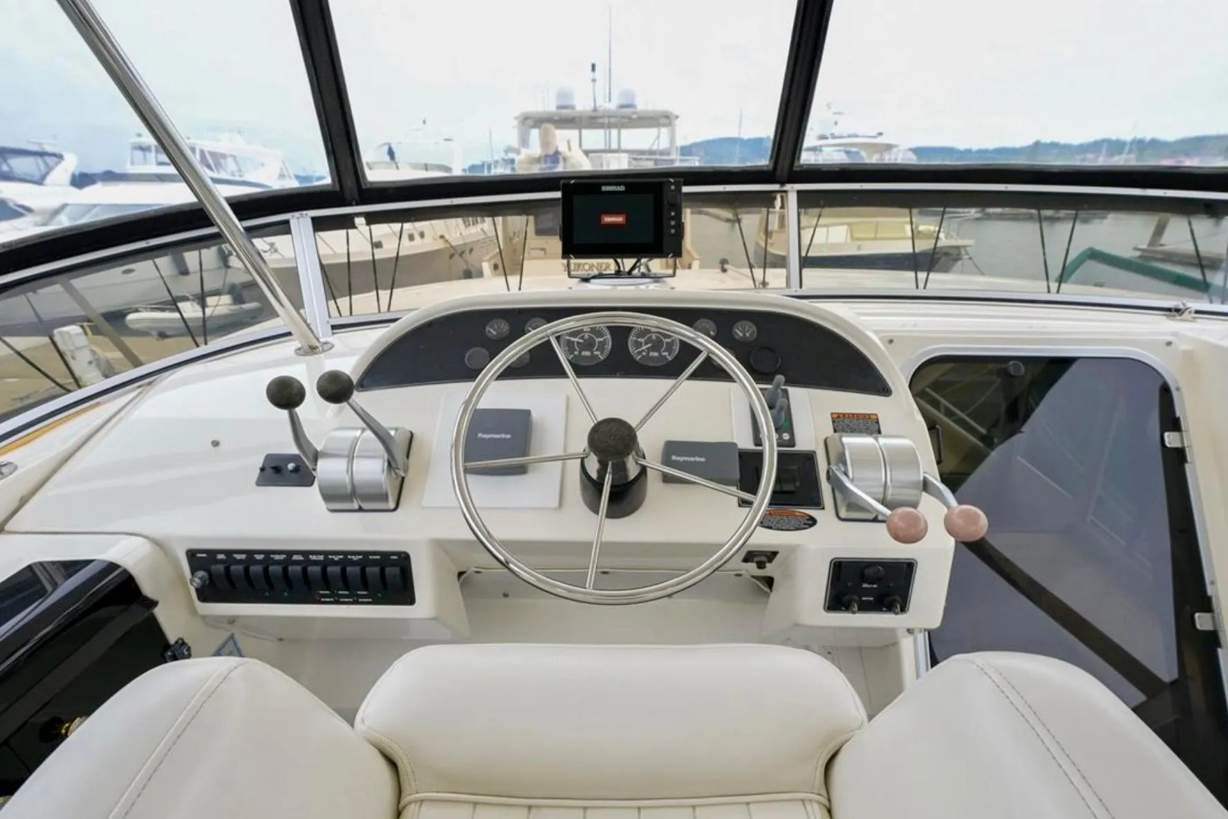 Pilothouse of 2004 Meridian 490, featuring steering wheel and navigation controls.