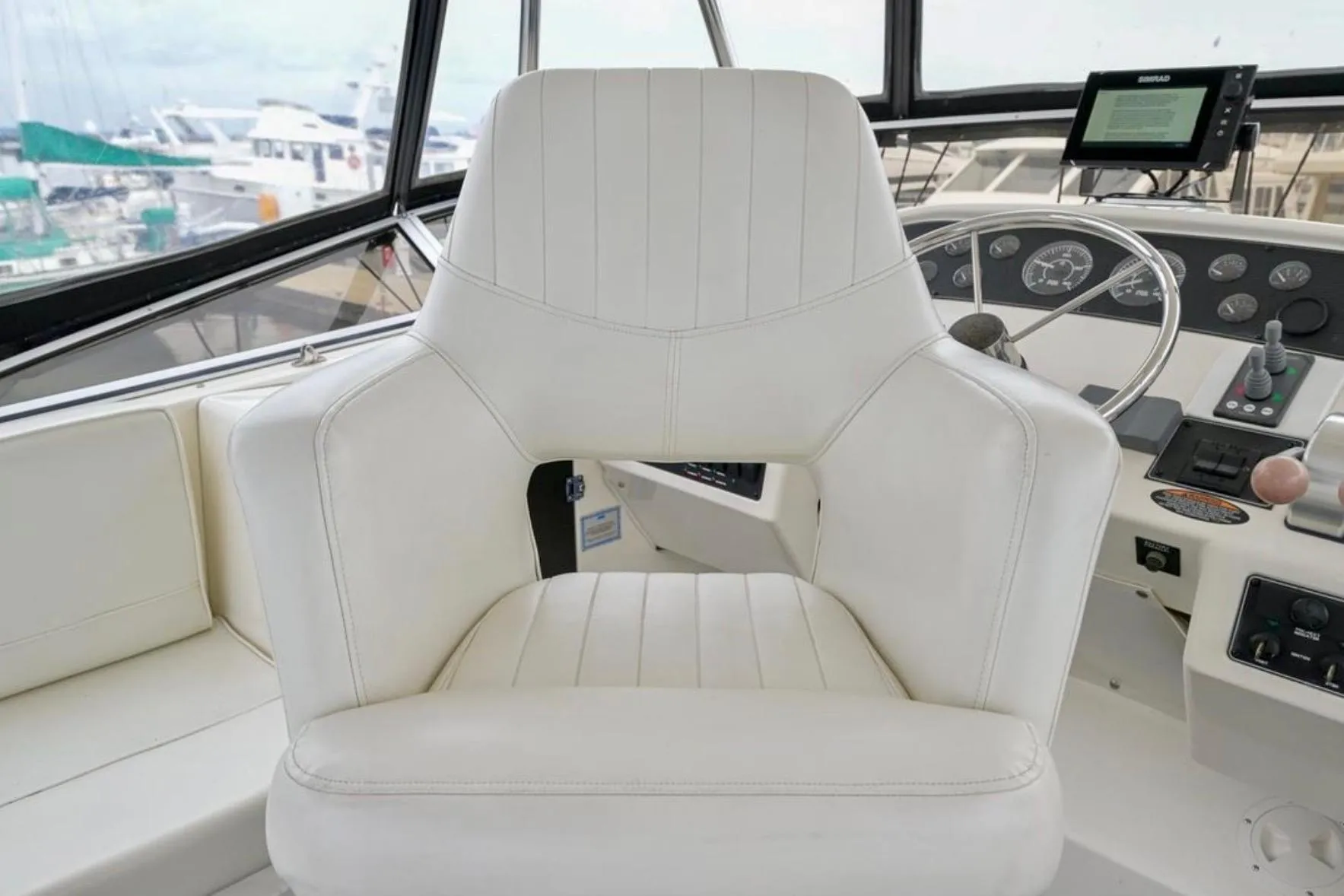 Captain's chair in 2004 Meridian 490 Pilothouse yacht cockpit, featuring navigation controls.