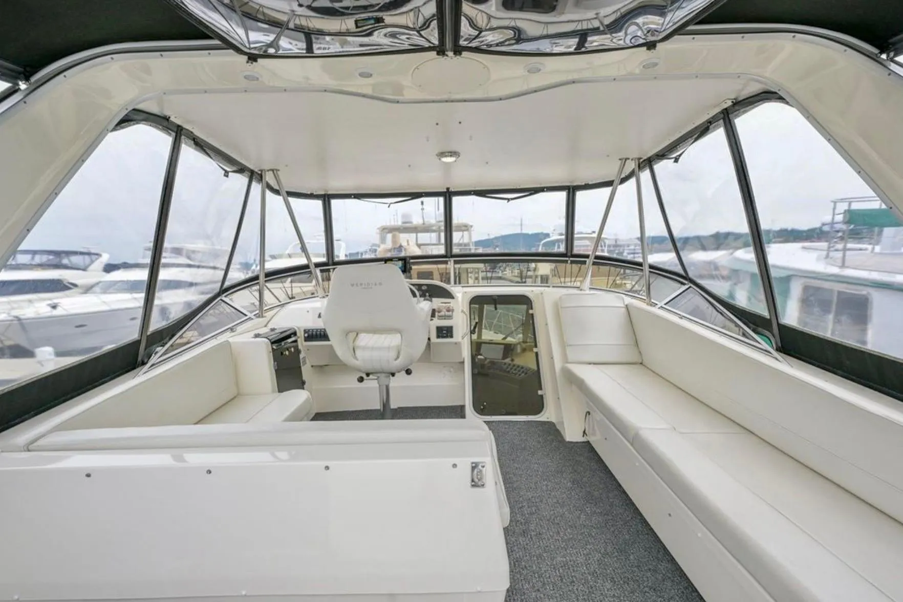 2004 Meridian 490 Pilothouse interior with spacious seating and helm, docked at marina.