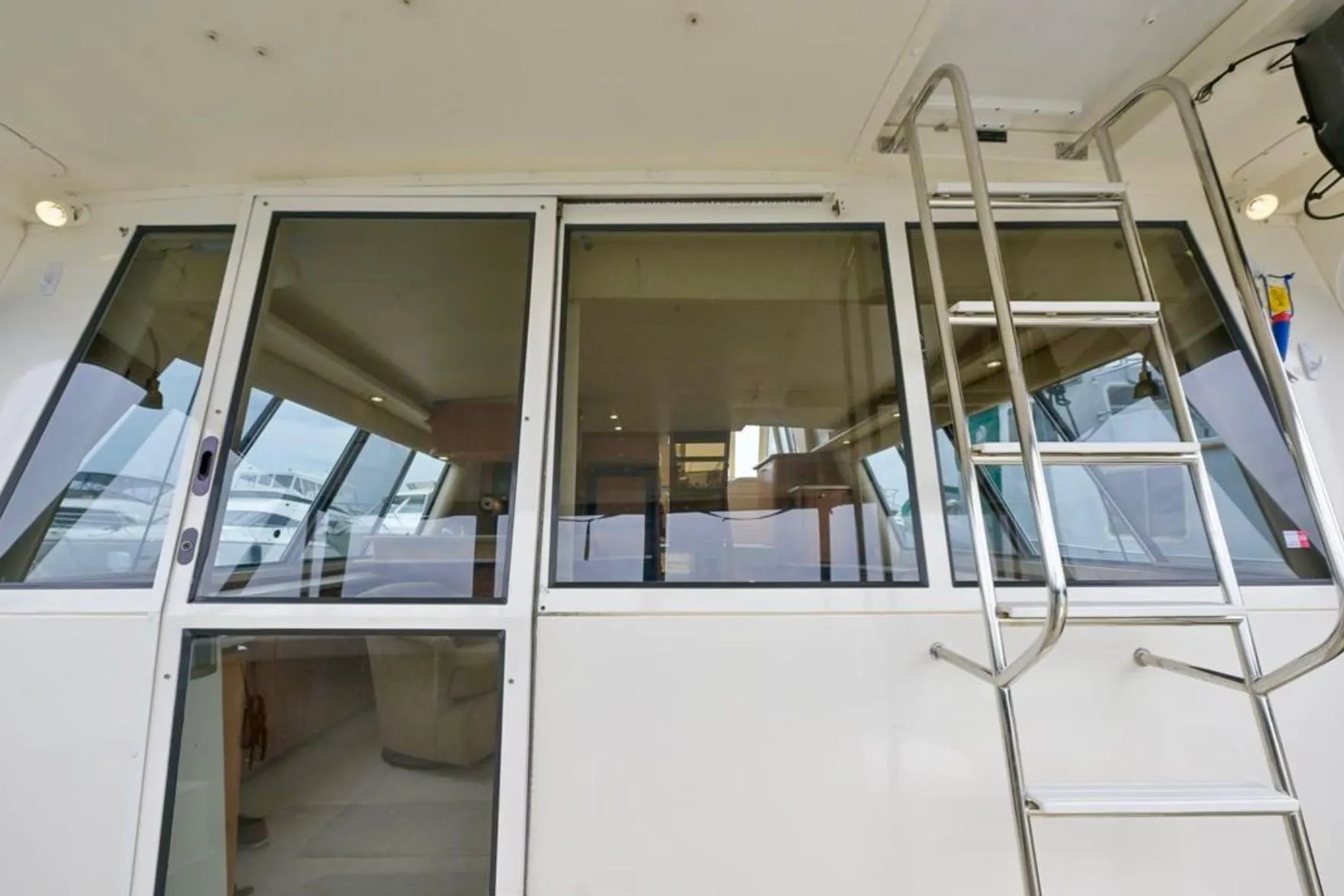 2004 Meridian 490 Pilothouse yacht with glass doors and ladder, showcasing interior.