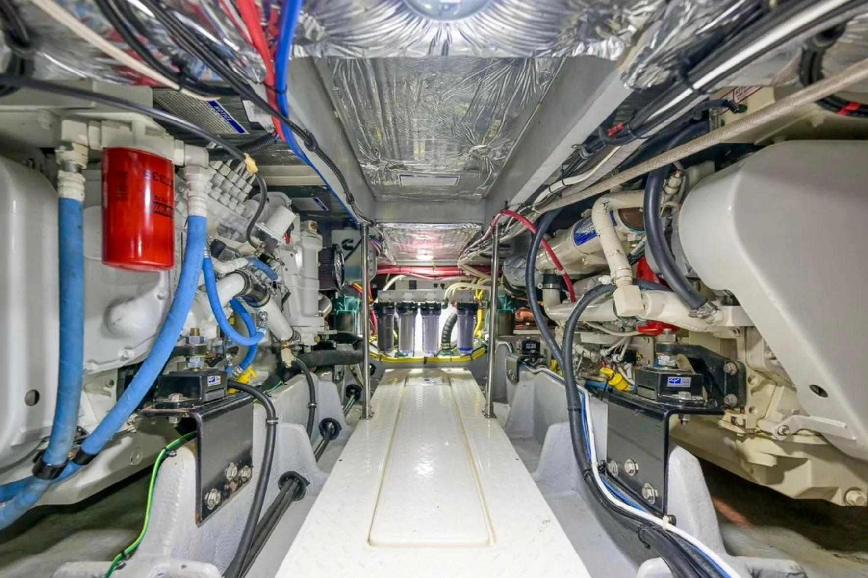 Engine room of 2004 Meridian 490 Pilothouse yacht, showcasing complex machinery and wiring.