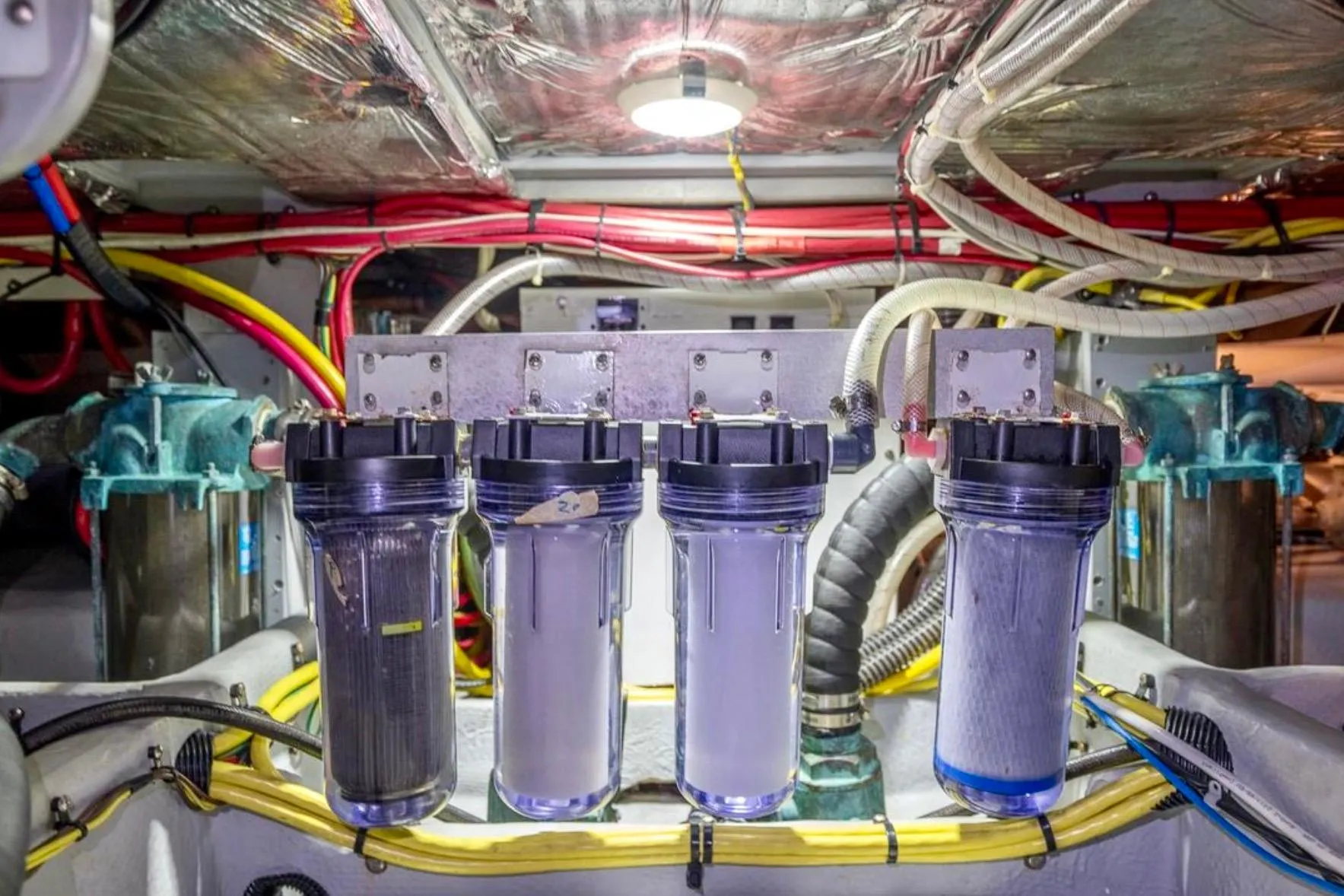 Engine room of 2004 Meridian 490 Pilothouse with water filtration system and wiring.