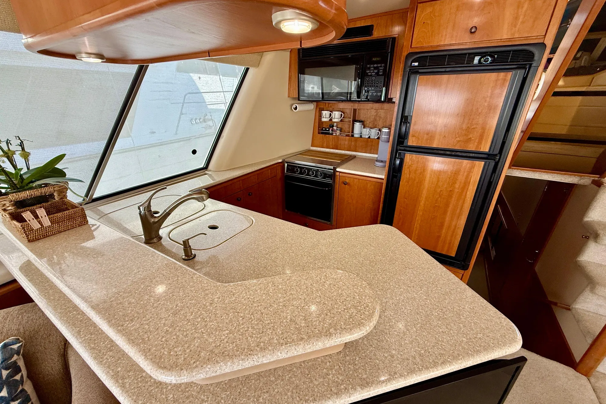 Luxurious 2004 Meridian 490 Pilothouse kitchen with modern appliances and elegant wood cabinetry.